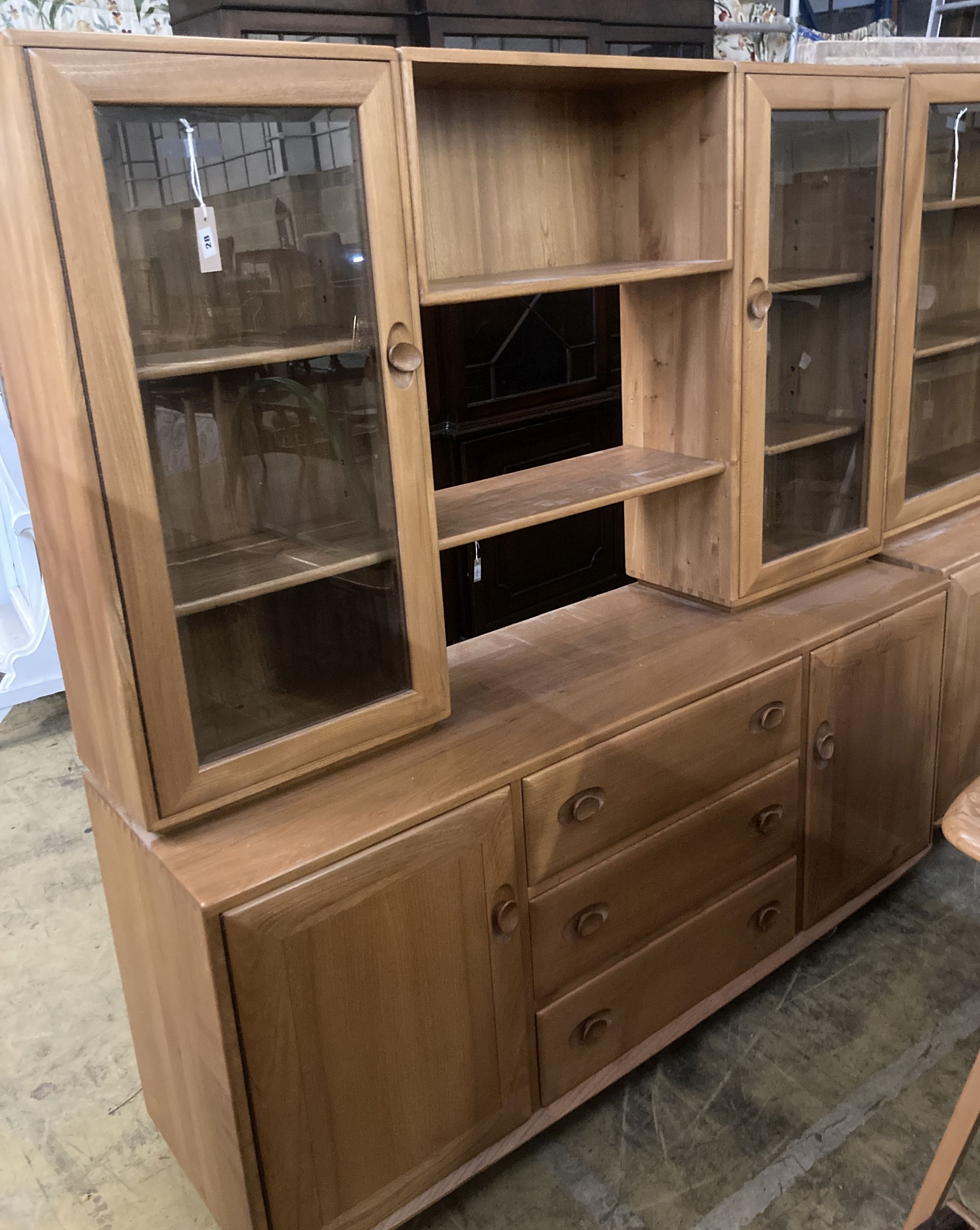 An Ercol elm glazed bookcase, width 155cm depth 44cm height 162cm